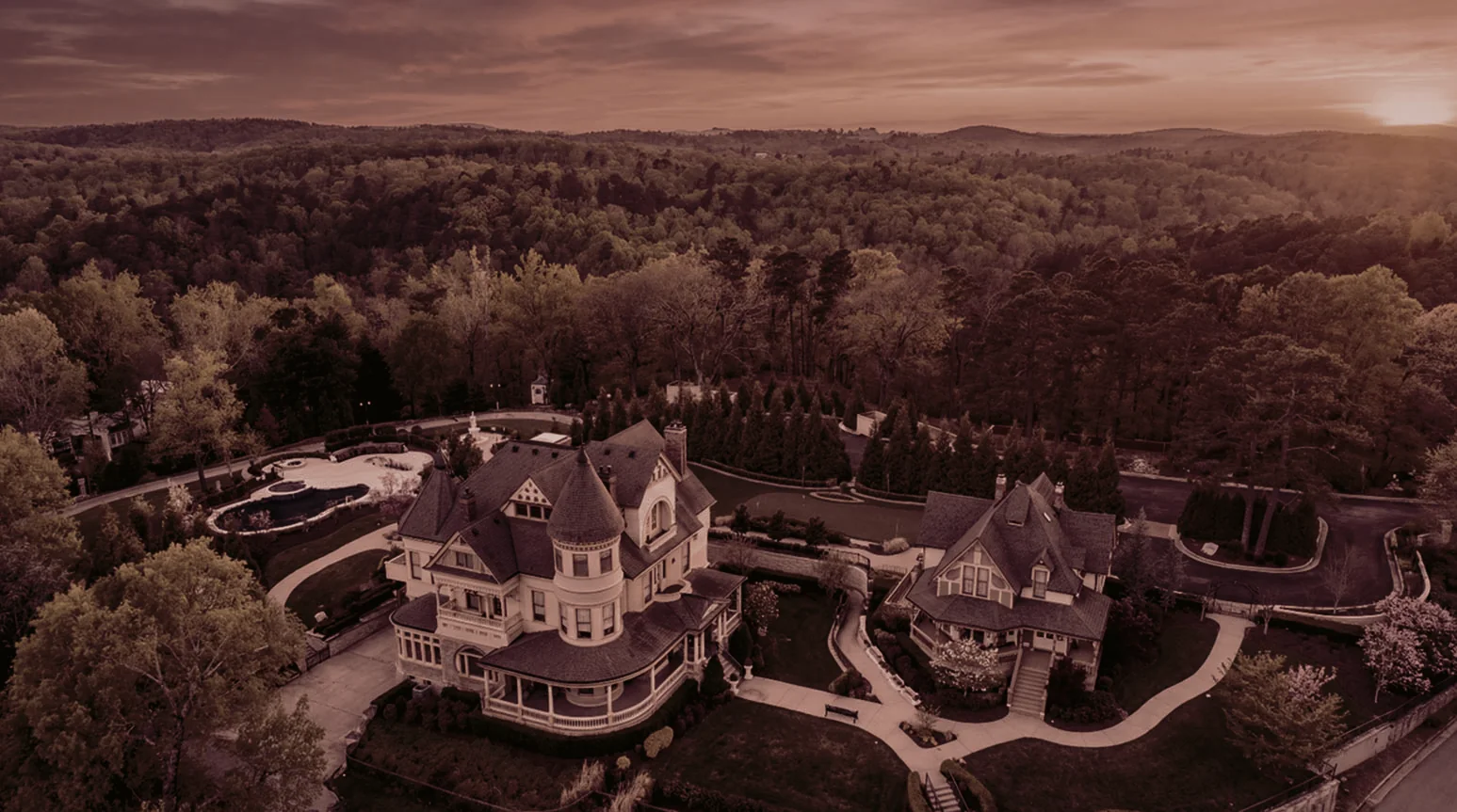 Lovell Estate from the air at dusk — the 1891 Queen Anne house on its hill above Eureka Springs.