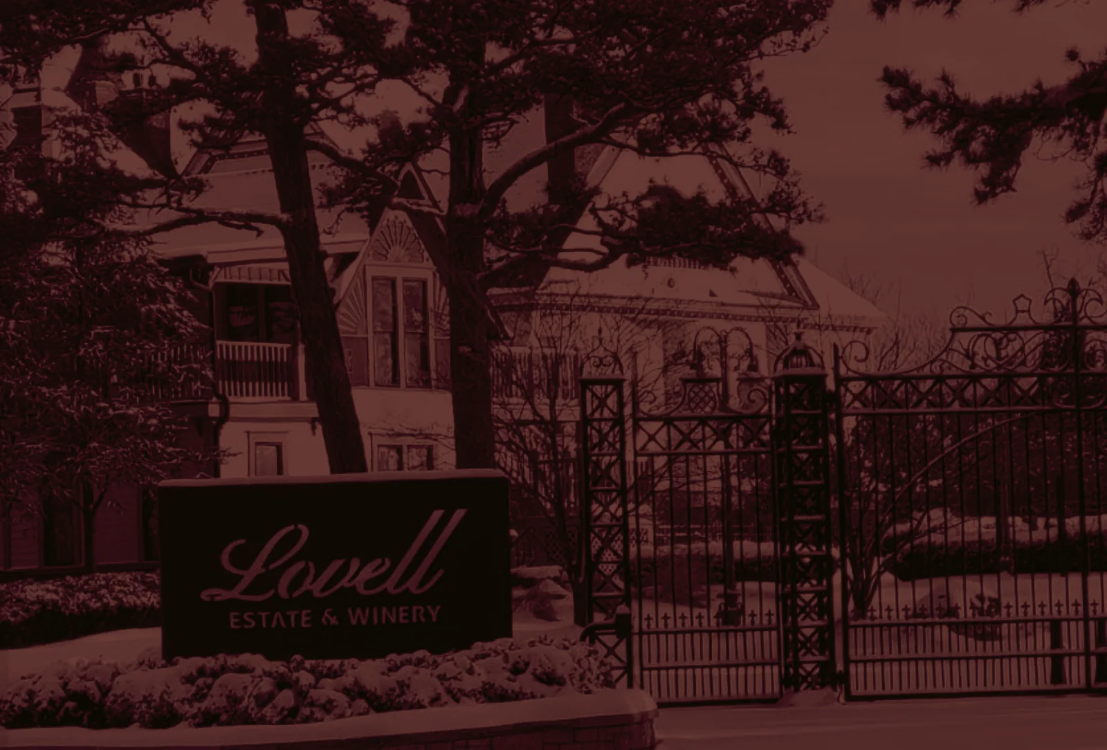 The estate gates and the Lovell Estate sign, the house rising behind the pines.
